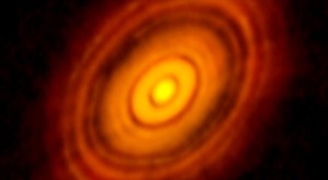 صورة حقيقية التقطها التلسكوي منعدد اللواقط للأمواح تحت ال ميليمتر ALMA لنظام شمسي في مراحله الأولى من التكوّن وتضح كيف تقوم الكواكب بتنظيف مساراتها من الأنقاض